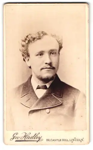 Fotografie Geo. Hadley, Lincoln, 36 Castle Hill, Portrait charmant blickender junger Mann mit lockigem Haar