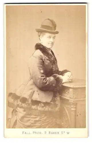 Fotografie T. Fall, London-W, 9 Baker Street, Portman Square, Portrait junge Dame in winterlicher Jacke mit Hut