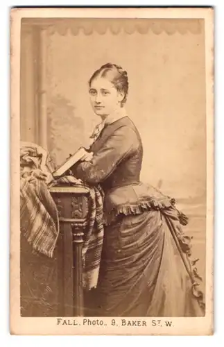 Fotografie T. Fall, London-W, 9 Baker Street, Portman Square, Portrait festlich gekleidete Dame mit Buch