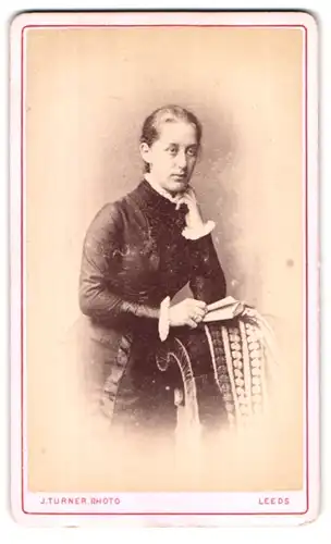 Fotografie J. Turner, Leeds, Portrait modisch gekleidete Dame mit einem Buch