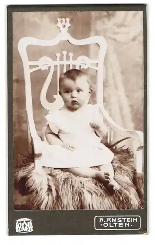 Fotografie A. Amstein, Olten, Portrait süsses Kleinkind im weissen Hemd mit nackigen Füssen