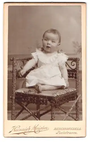 Fotografie Heinrich Miester, Bischofszell, Poststrasse, Portrait süsses Kleinkind im weissen Kleid mit nackigen Füssen
