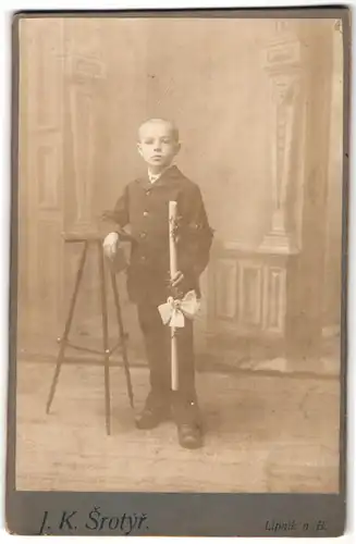 Fotografie J.K. Srotyr, Lipnik n./B., Portrait Knabe im Anzug mit Kommunionskerze