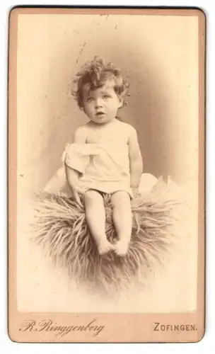 Fotografie R. Ringgenberg, Zofingen, oberer Stadteingang, niedliches kleines Kind auf Fell sitzend