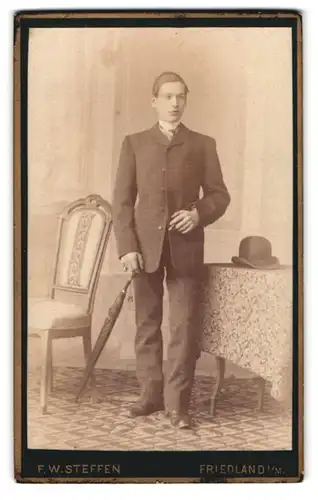 Fotografie F. W. Steffen, Friedland, eleganer junger Mann mit Schirm Melone und Zigarre