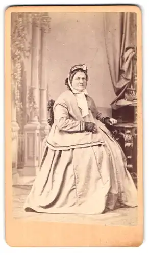 Fotografie J. Jungmann, Kl. Basel, Hammerstr. 13, Portrait ältere Frau im Reifrock mit Schute