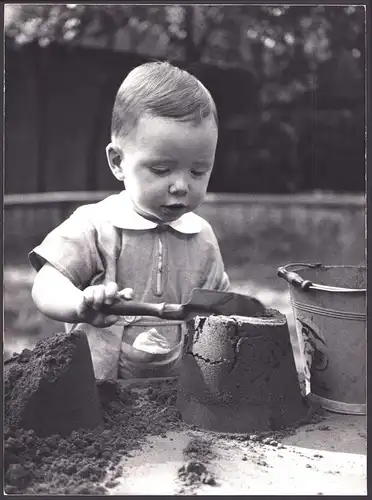 Fotografie Thomas A. Müller, Ammersbek, Knabe spielt mit Schippe und Eimer im Sandkasten, Grossformat 28 x 39cm