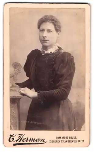 Fotografie C. Herman, Camberwell Green, Church St. 72, Frau mit ernstem Blick und Locken in Kleid mit Rüschenärmeln