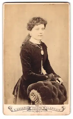 Fotografie J.S. Hazard, London, Mädchen mit Lockenfrisur und Halskette in Samtkleid