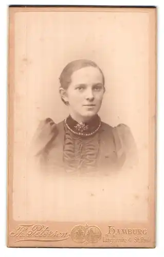 Fotografie Th. Petersen, Hamburg-St. Pauli, Langereihe 4, Portrait hübsches Fräulein mit Brosche und Halskette am Kragen