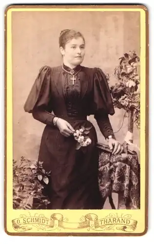 Fotografie O. Schmidt, Tharand, Portrait bildschöne junge Frau mit Kreuz-Kette und Blume in der Hand