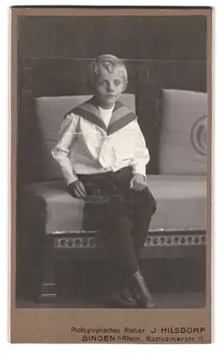 Fotografie J. Hilsdorf, Bingen a. Rh., Kapuzinerstr. 11, Portrait blonder frecher Bube im Matrosenanzug