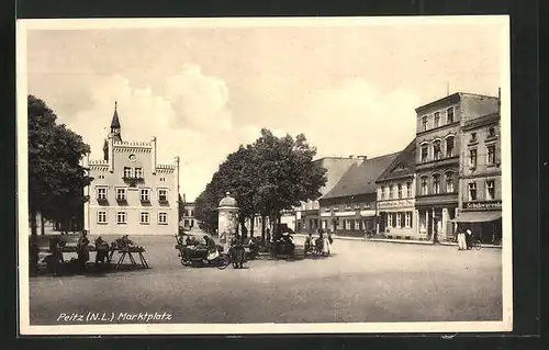 AK Peitz /N.-L., Marktplatz mit Geschäften und Litfasssäule