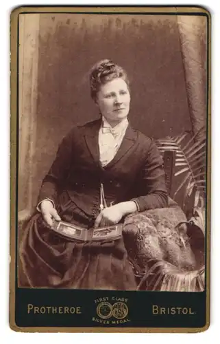 Fotografie J. Protheroe, Bristol, 35 & 36, Wine Street, Portrait modisch gekleidete Dame mit Fotoalbum
