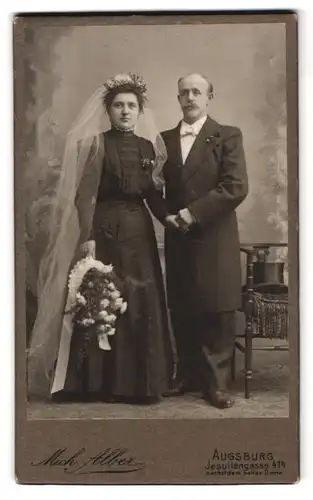 Fotografie Mich. Alber, Augsburg, Jesuitenstr. 414, Portrait Hochzeitpaar gekleidet in Schwarz mit Blumenstrauss