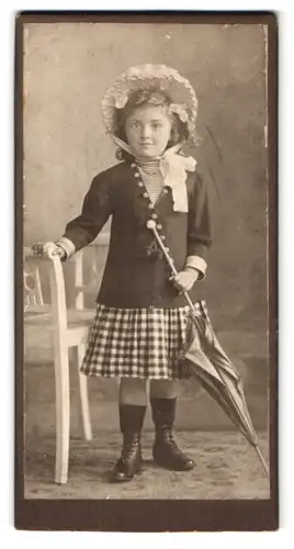 Fotografie H. Deike, Hannover-Linden, Deisterstr. 7, Portrait kleines Mädchen im karierten Rock mit Haube und Schirm