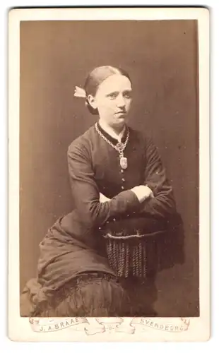 Fotografie J. A. Braae, Svendborg, Gjeritsgade 25, Portrait junge Frau im schwarzen Kleid mit Kette und Anhänger