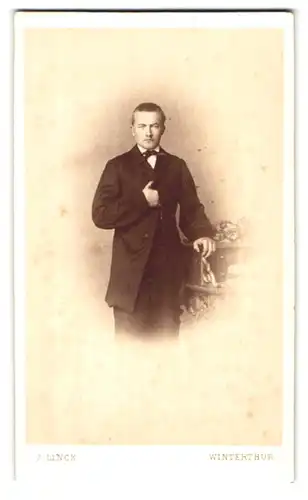 Fotografie J. Linck, Winterthur, Portrait Mann im Anzug und Fliege mit Napoleon Geste