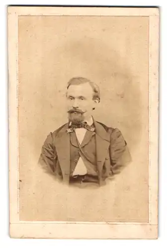 Fotografie Fotograf und Ort unbekannt, Portrait Mann im Anzug mit Fliege und Henriquatre Bart