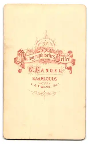 Fotografie W. Kandel, Saarlouis, v. d. französ. Thor, Portrait junge Frau im Biedermeierkleid vor einer Studiokulisse
