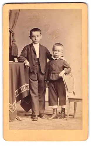 Fotografie L. Belitski, Nordhausen, Portrait zwei Brüder in Anzügen stehen im Atelier