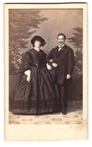 Fotografie Fotograf und Ort unbekannt, elegantes Paar, Dame im tailierten Kleid nebst Gatte im Anzug