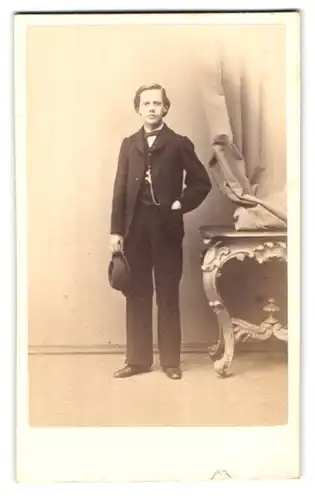 Fotografie G. Linde, Putbus, Portrait Junge im schwarzen Anzug mit Hut und Fliege
