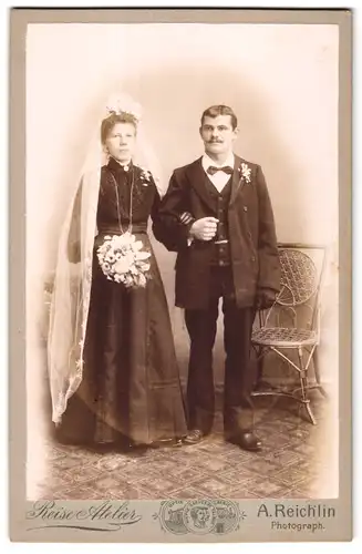 Fotografie A. Reichlin, Ort unbekannt, Portrait frisch vermähltes Hochzeitspaar im schwarzen Kleid mit Schleier