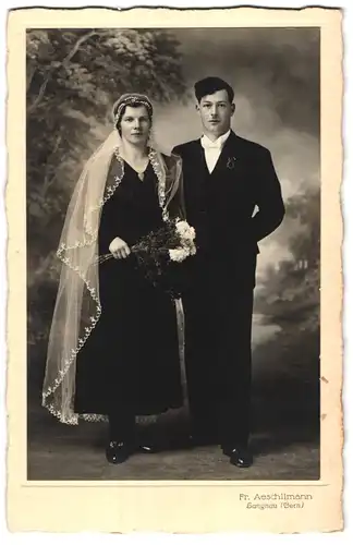 Fotografie Fr. Aeschlimann, Langnau, Portrait Hochzeitspaar im schwarzen Kleid, weisser Schleier, Mann mit Oberlippenbart
