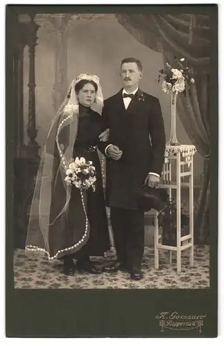 Fotografie A. Gossauer, Rapperswil, Portrait junges Hochzeitspaar im schwarzen Kleid mit Schleier, Anzug mit Zylinde