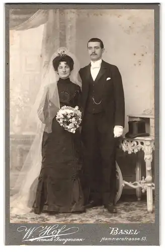 Fotografie W. Hof, Basel, Hammerstr. 53, Portrait Eheleute im schwarzen Brautkleid mit Schleier und Zylinder