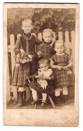Fotografie Fotograf und Ort unbekannt, Mädchen mit Puppe, Blumenstrauss & Halskette