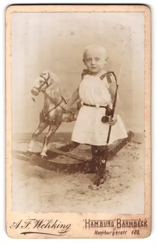 Fotografie A. F. Wehking, Hamburg-Barmbeck, Hamburgerstr. 129, Kind mit Reitgerte und Schaukelpferd