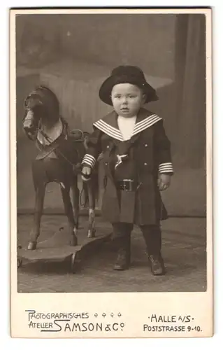 Fotografie Samson & Co., Halle a. S., Poststr. 9-10, Portrait Kleinkind mit Schaukelpferd in Matrosenoutfit