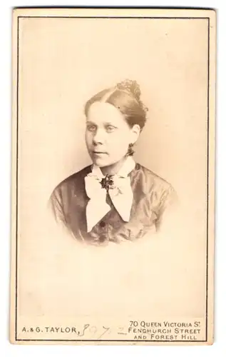 Fotografie A. & G. Taylor, London, 70 Queen Victoria Street, Portrait bildschöne junge Frau mit Schleife am Blusenkragen