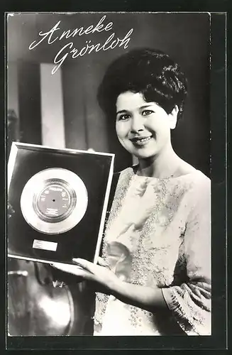 AK Musikerin Anneke Grönloh hält eine goldene Schallplatte in der Hand