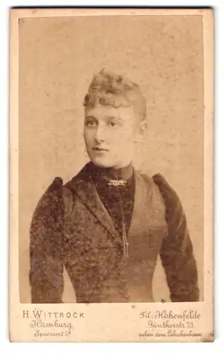 Fotografie H. Wittrock, Hamburg, Speersort 5, Portrait blonde Schönheit mit Brosche am Kleiderkragen