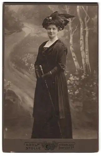 Fotografie Adolf Stolle, Hamburg, Speersort 5, Portrait ältere Dame im schwarzen Kleid mit Gehstock vor Studiokulisse