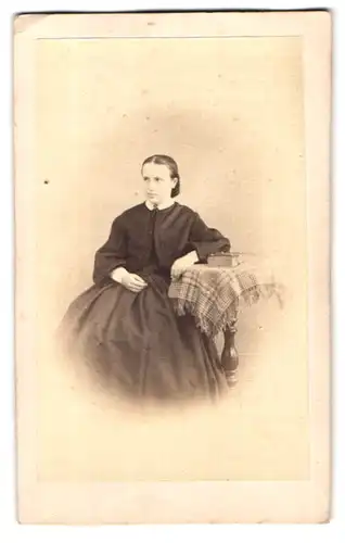 Fotografie J. Schelling, Brackenheim, Portrait junge Frau im schwarzen Kleid sitzt an einem Tisch