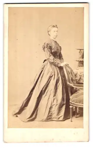 Fotografie j. Schäfer, Frankfurt a. M., Hochstr. 40, Portrait junge Dame im seidenen Kleid steht an einem Stuhl