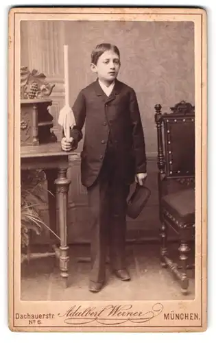 Fotografie Adalbert Werner, München, Dachauerstr. 6, Portrait junger Knabe im Anzug mit Kerze und Hut zur Kommunion