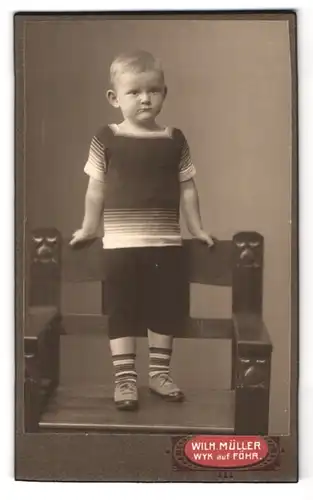 Fotografie Wilhelm Müller, Wyk /Föhr, Sandwall, Bub mit Ringelsöckchen