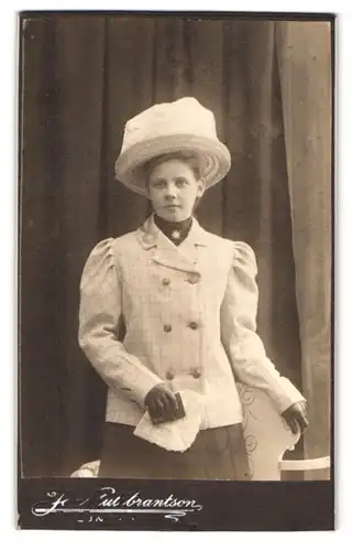 Fotografie Ida Gullbrantson, Lund, Stortorget 4, Portrait junge Frau im karierten Blazer mit Hut