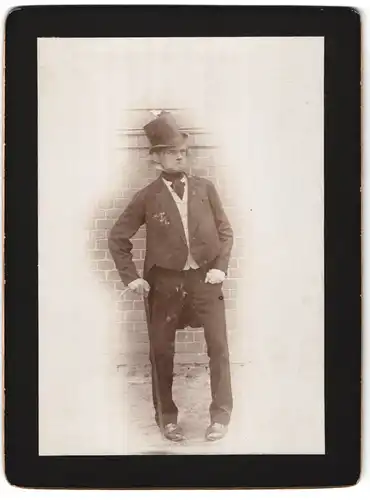 Fotografie Fotograf und Ort unbekannt, Portrait Humorist im Anzug mit Zylinder und Stock, O-Beine