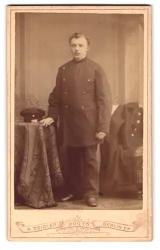 Fotografie H. Zeidler, Berlin, Jerusalemerstr. 59, Portrait Postbeamter in Uniform mit Locken