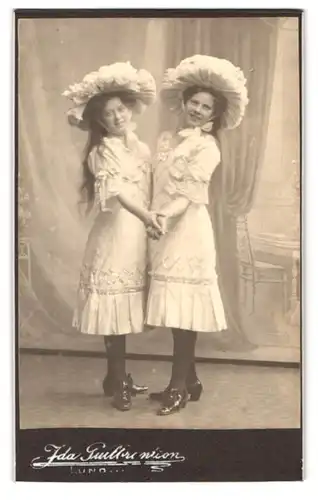 Fotografie Ida Gullbrantson, Lund, Stortorget 4, Portrait zwei Frauen in weissen Kleidern mit Hut und Lackschuhen