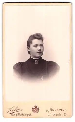 Fotografie H. Holm, Jönköping, Ö. Storgatan 53, Portrait junge Frau der schwed. Heilsarmee, Abzeichen am Kleiderkragen