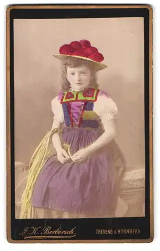 Fotografie J. K. Berberich, Triberg, Portrait Mädchen in Tracht spinnt Stroh, coloriert