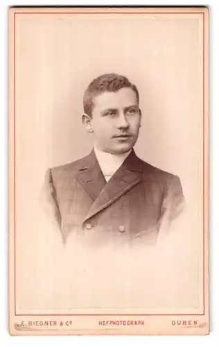 Fotografie E. Beigner & Co., Guben, Wilhelmsplatz 9, Portrait junger Herr im karierten Anzug