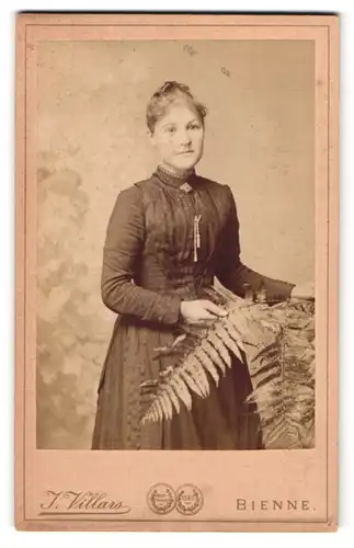 Fotografie J. Villars, Bienne, Frau in tailliertem Kleid mit Farnblättern